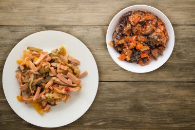 Berlin salatası ahşap bir arka planda beyaz bir tabakta. Sosis, salatalık, biber soslu salata. .