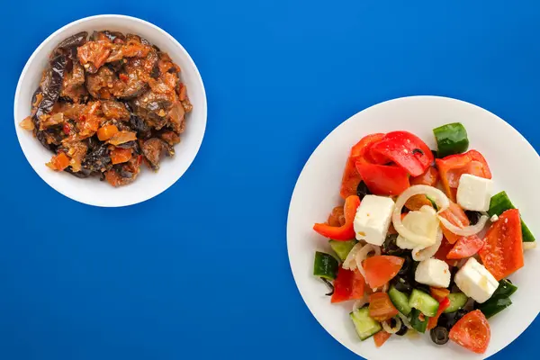 蓝色背景的希腊色拉 希腊色拉在白色的盘子顶部视图 健康的食物 — 图库照片