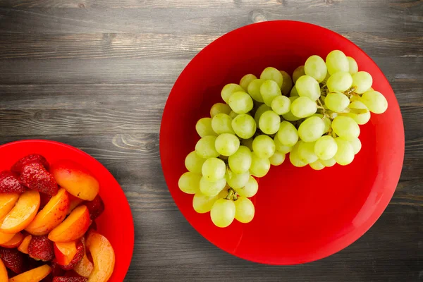 grapes on a black wooden background. grapes on a red plate.healthy vegetarian food