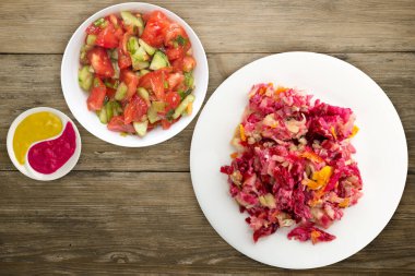 Beyaz bir tabakta kürk manto altında ringa balığı. Ahşap bir arka planda kürk mantonun altında ringa balığı. Ringa, pancar, havuç, mayonez ve soğan salatası. .