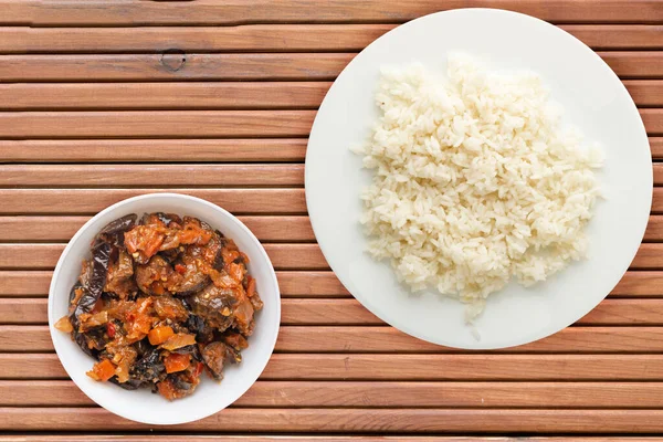 white rice on a white  plate. rice with vegetable salad  on a orange wooden background top view .asian food
