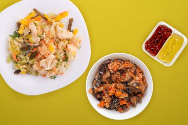  Beyaz tabakta sebze turşusu. Sarı arka planda vejetaryen yemekleri. Kırsal yiyecekler. Düz yatıyordu.