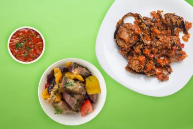 Beyaz bir tabakta limon arkaplanda domates ve biberli kabak yahnisi. Vejetaryen yemeği. Sağlıklı kahvaltı manzarası. Düz yatıyordu.