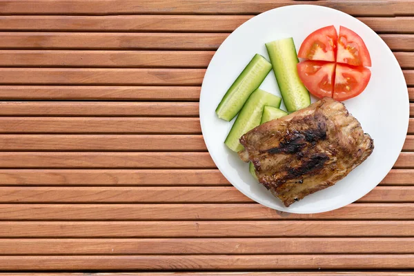 Gegrillte Schweinerippchen Mit Gurkenscheiben Und Tomaten Auf Einem Weißen Teller — Stockfoto