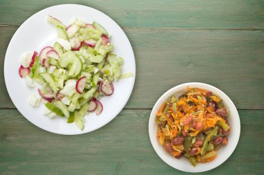 Salatalıklı salata ve beyaz tabakta yumurta yeşil ahşap arka planda sağlıklı yemek. Vejetaryen yemeği. Asya mutfağı