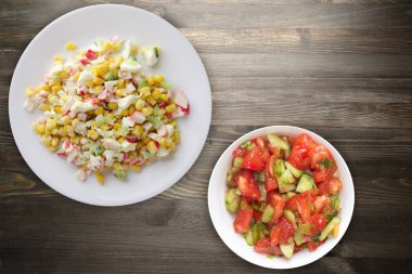 Vejetaryen salatalı beyaz tabakta yengeç salatası. Siyah ahşap arka planda yengeç salatası.