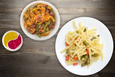 sarımsak ve havuçlu yeşil fasulyeli makarna beyaz tabakta siyah ahşap arka planda. Akdeniz Mutfağı. Sebzeli makarna..