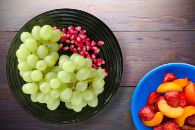 Üzüm, mor ahşap arka planda nar. Üzüm, nar ve meyve salatası.