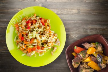  Tavuk mideli salata ile sebze havuç, soğan, biber, lahana, domates, brokoli. Limonlu tavuklu salata, siyah ahşap arka plan manzaralı.