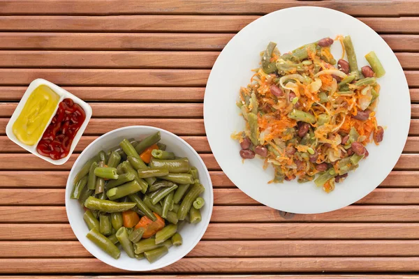素食沙拉顶视图 健康食品 胡萝卜和芝麻色拉在橙色木制背景的白盘上 — 图库照片