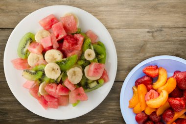 Kahverengi ahşap arka planda sağlıklı taze meyve salatası. .