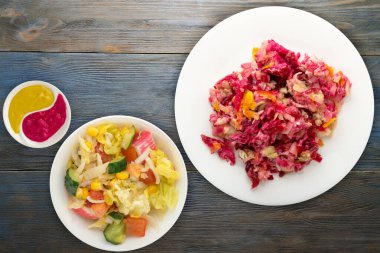 Beyaz bir tabakta kürk manto altında ringa balığı. Mavi ahşap arka planda kürk manto altında ringa balığı. Ringa, pancar, havuç, mayonez ve soğan salatası. .