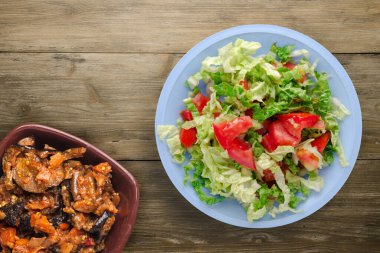 Vejetaryen yemeği. Kahverengi ahşap arka planda açık mavi tabakta lahana salatası. sağlıklı yiyecekler