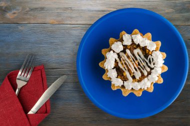 Çatallı pasta ve mavi ahşap arka planda bıçak. kek mavi bir plaka görünümünde