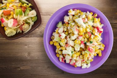 Mor tabakta sebze salatası manzaralı yengeç salatası. Kahverengi ahşap arka planda yengeç salatası