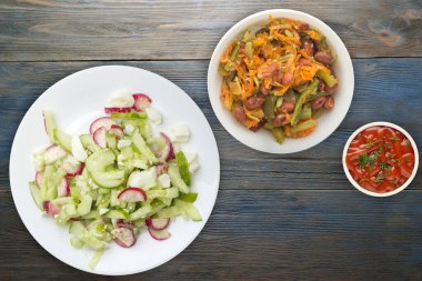 Salatalıklı salata ve mavi ahşap arka planda beyaz bir tabakta yumurta. Sağlıklı yemek. Vejetaryen yemeği. Asya mutfağı