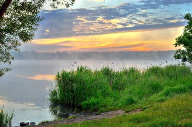 Güzel gökyüzü ve göl kenarında yeşil çimen.
