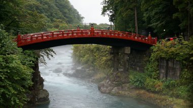 Kızıl Shinkyo köprüsü Nikko 'da fırtınalı bir nehirde, yağmurlu bir günde, Japonya' da.