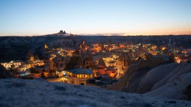Kapadokya, Anadolu 'da gece yarısı arka planda Goreme kasabası ve Uchisar kalesi. 