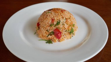 Beyaz tabakta sebzeli baharatlı pilav, restoranda akşam yemeği..   