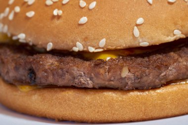 Biftek, peynir ve susam tohumlu taze bir hamburger yakın çekim.
