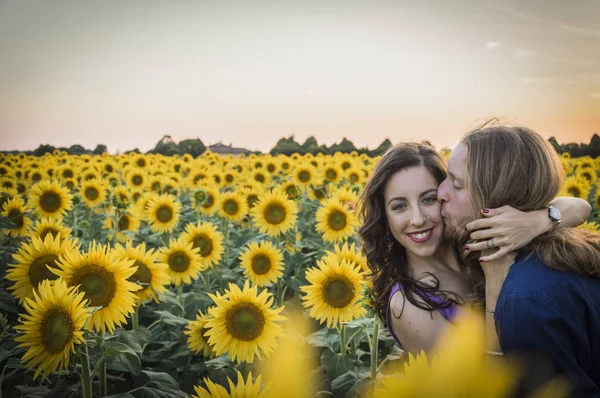 Jong koppel bij zonnebloemen veld — Stockfoto