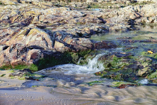 Швидкий потік води через скелі з водоростями — стокове фото