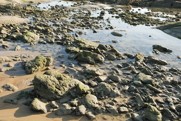 Вид на синее море и камни и пляж на закате — стоковое фото