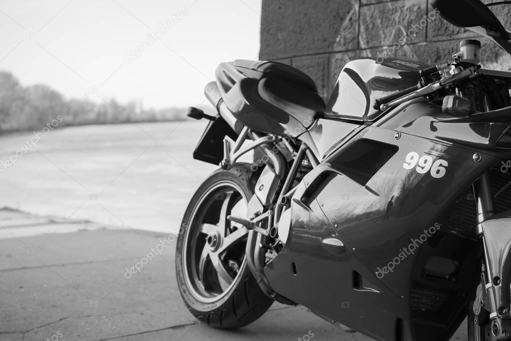 Senta, Serbia: March 4th, 2017. Close-up of beautiful red Ducati 996s motorcycle, photographed outdoor on a dock in Senta, on a public walk way. Sign 996 in focus. Black and white photo.