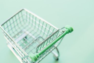 Yeşil arka plan üzerinde boş alışveriş sepeti