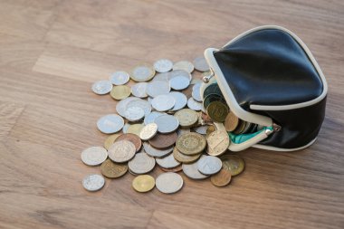 Ahşap yüzey üzerinde farklı paralar ile siyah deri cüzdan