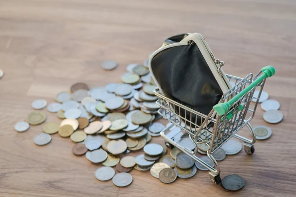 Shopping cart with wallet and coins on the wooden table — Stock Photo, Image