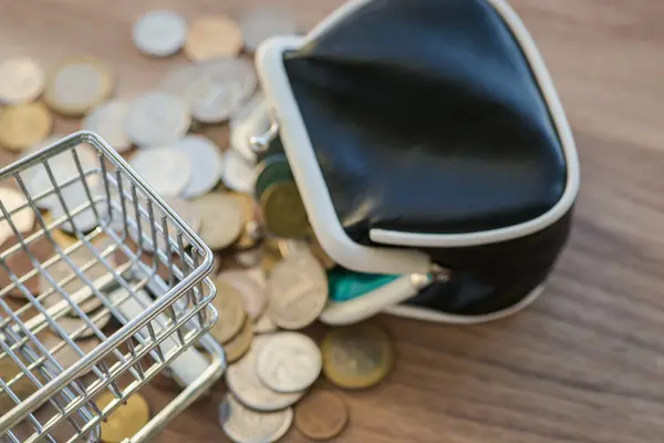 Koszyk z portfela i monety na drewnianym stole — Zdjęcie stockowe