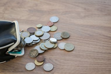 Ahşap yüzey üzerinde farklı paralar ile siyah deri cüzdan