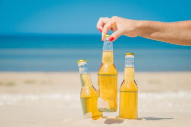 Buz soğuk bira şişeleri kum güneşin altında