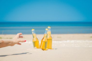 Buz soğuk bira şişeleri kum güneşin altında
