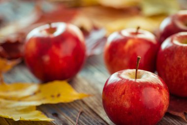 Kırmızı sonbahar elma ile akçaağaç yaprakları üzerinde ahşap masa