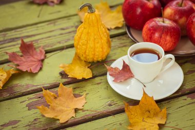 Dekoratif kabak ve koyu ahşap bir masa üzerinde çay