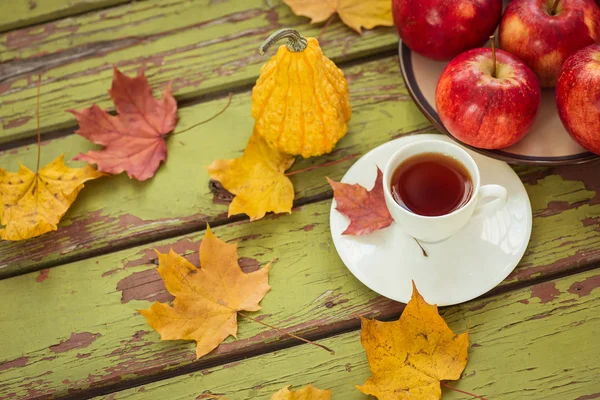 Dekoratif kabak ve koyu ahşap bir masa üzerinde çay