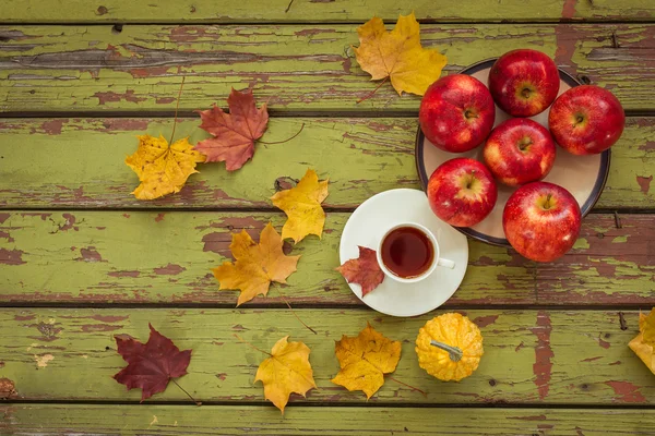 Dekoratif kabak ve koyu ahşap bir masa üzerinde çay
