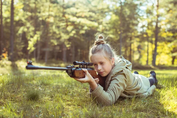 Girl shooting from the air rifle in the forest — Stock Photo, Image