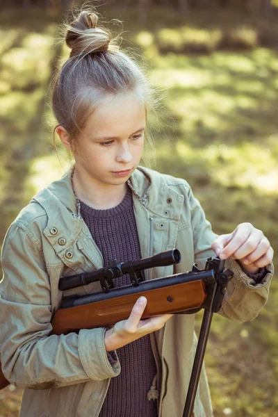 Flicka skytte från luft gevär i skogen — Stockfoto