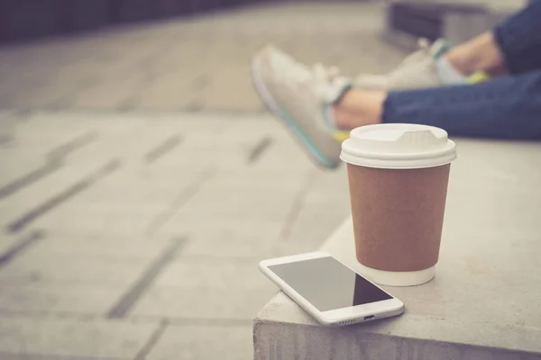 Kaffee to go und Smartphone auf dem Betonklotz — Stockfoto