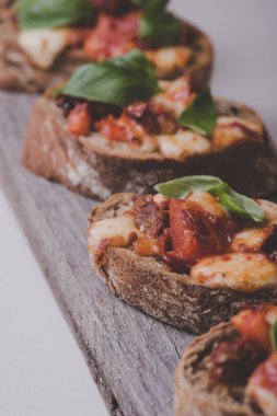Gıda. Bir ahşap tahta üzerinde peynir ile lezzetli bruschettas
