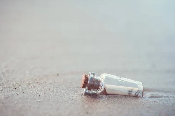 Message dans la bouteille lavé de la mer contre le coucher du soleil — Photo