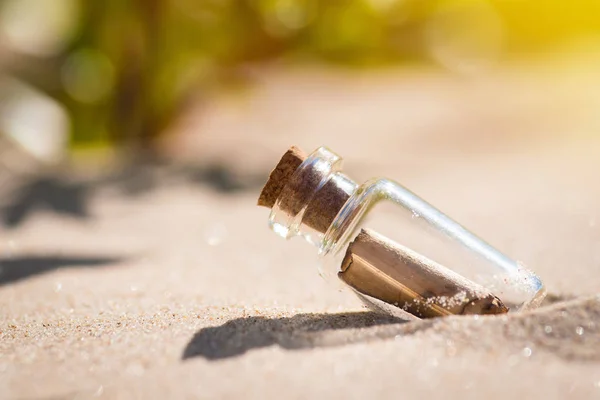 Bericht in de fles weggespoeld uit de zee tegen de ondergaande zon naar beneden — Stockfoto