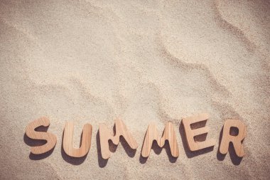 Yaz. Kum üzerinde ahşap harfler