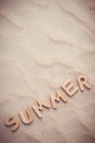 Yaz. Kum üzerinde ahşap harfler