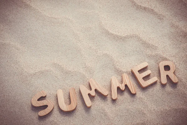 Yaz. Kum üzerinde ahşap harfler