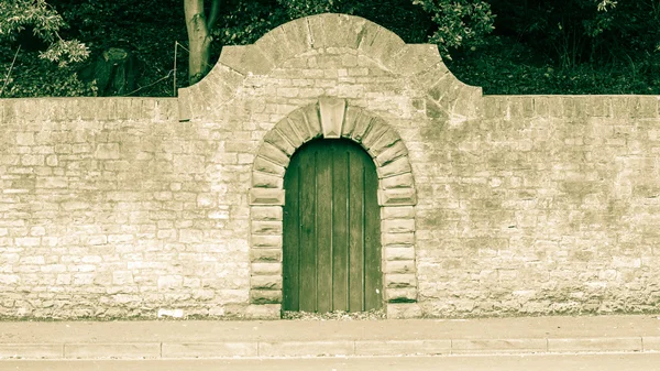 Alte Holztür mit Rundbogen aus Stein Stockbild